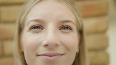 Sokakta kendine güvenen genç sarışın kadın gülümsüyor