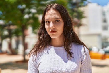 Young woman with relaxed expression standing at park