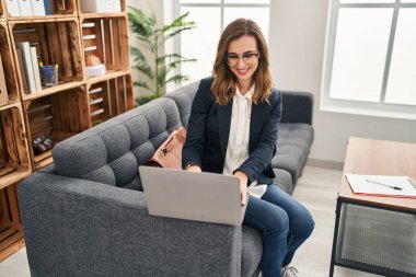 Klinikte dizüstü bilgisayar kullanan genç bir kadın.