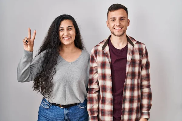 Young Hispanic Couple Standing White Background Showing Pointing Fingers Number — Stockfoto