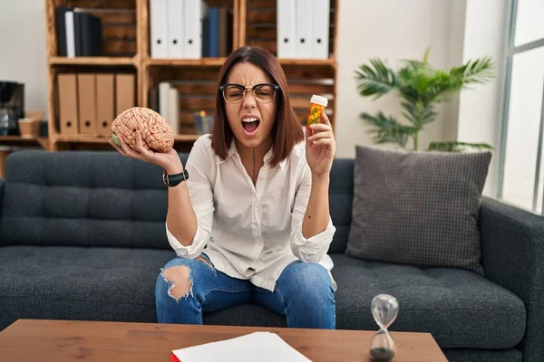 Young Hispanic Woman Working Depression Holding Pills Angry Mad Screaming — Stockfoto