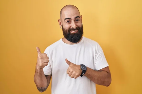 Young Hispanic Man Beard Tattoos Standing Yellow Background Pointing Back —  Fotos de Stock