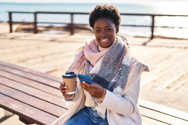 Afrika Kökenli Amerikalı Kadın Akıllı Telefon Kullanıyor Kahve Içiyor Deniz — Stok fotoğraf