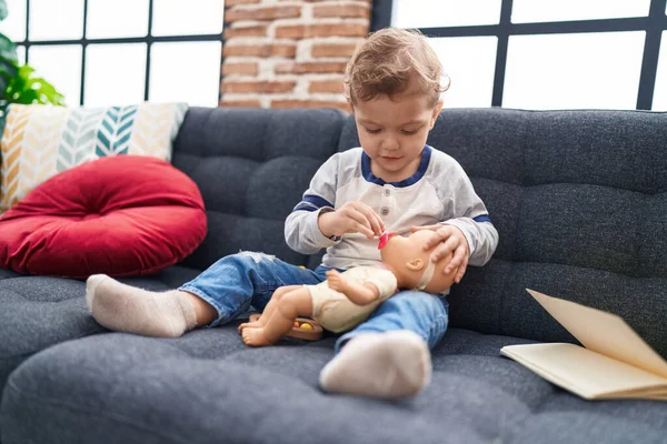 Beyaz Tenli Sevimli Çocuk Evdeki Kanepede Bebek Oyuncağıyla Oynuyor — Stok fotoğraf