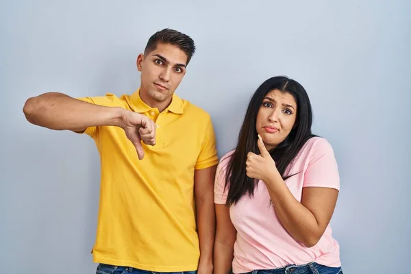 Young Couple Standing Isolated Background Doing Thumbs Disagreement Agreement Expression — Stockfoto