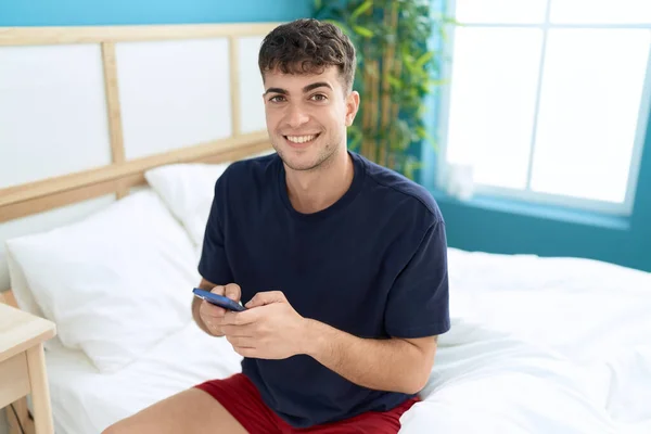 Young Hispanic Man Using Smartphone Sitting Bed Bedroom — Photo