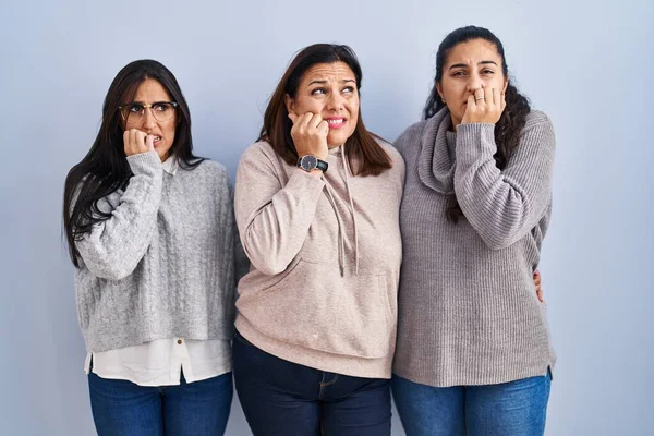 Mother Two Daughters Standing Blue Background Looking Stressed Nervous Hands — Stockfoto