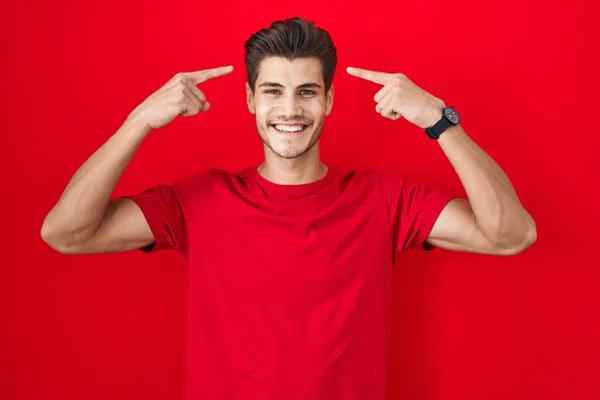 Young Hispanic Man Standing Red Background Smiling Pointing Head Both — Stockfoto