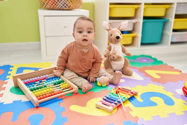 愛らしいヒスパニック幼児遊びとともにおもちゃで床に座って幼稚園 — ストック写真