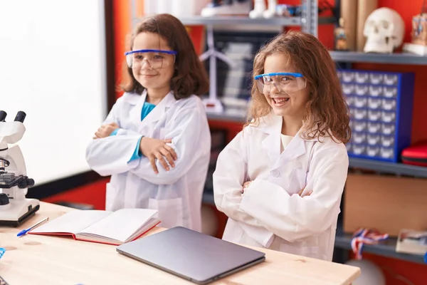 两个孩子手挽手站在实验室教室里 — 图库照片