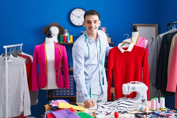 Jovem Hispânico Alfaiate Segurando Shirt Escrita Notebook Estúdio Costura — Fotografia de Stock