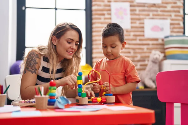 幼稚园时 老师和幼儿坐在桌子上玩玩具 — 图库照片