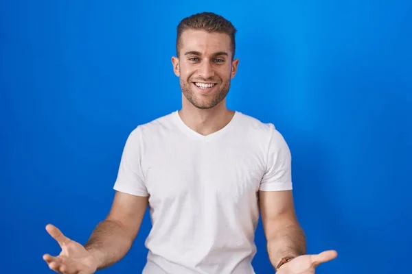 Young Caucasian Man Standing Blue Background Smiling Cheerful Open Arms — Foto de Stock