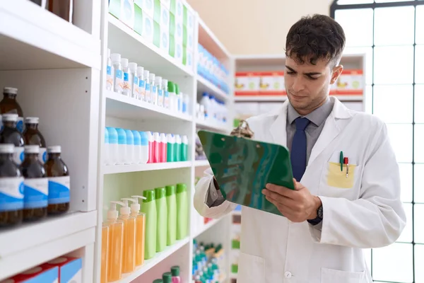 Young Hispanic Man Pharmacist Writing Clipboard Pharmacy — Zdjęcie stockowe
