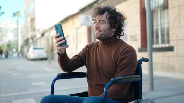 Young Hispanic Man Using Smartphone Sitting Wheelchair Street — стоковое фото
