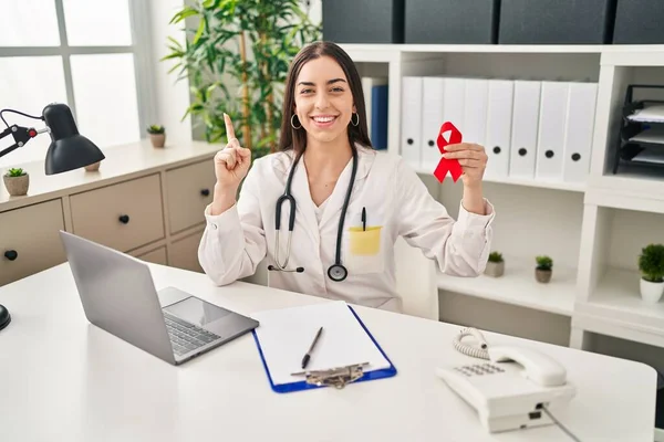 Hispanic Doctor Woman Holding Support Red Ribbon Surprised Idea Question — Foto de Stock