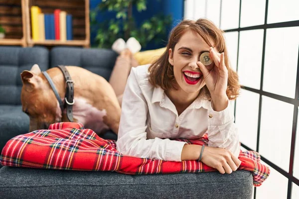 Young Caucasian Woman Holding Bitcoin Eye Lying Sofa Dog Home — Fotografia de Stock