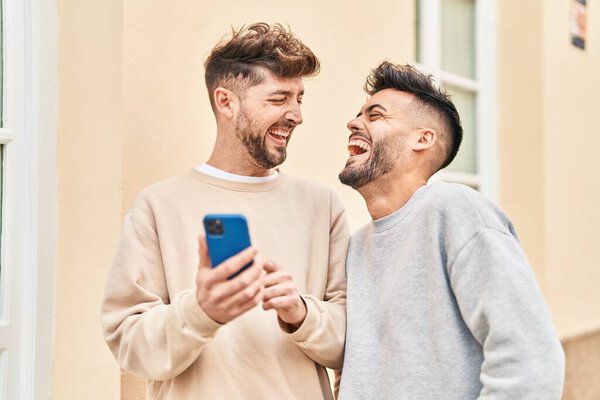 Young couple using smartphone standing together at street