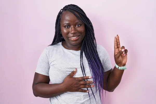 Fiatal Afrikai Áll Rózsaszín Háttér Felett Mosolyogva Káromkodik Kéz Mellkason — Stock Fotó