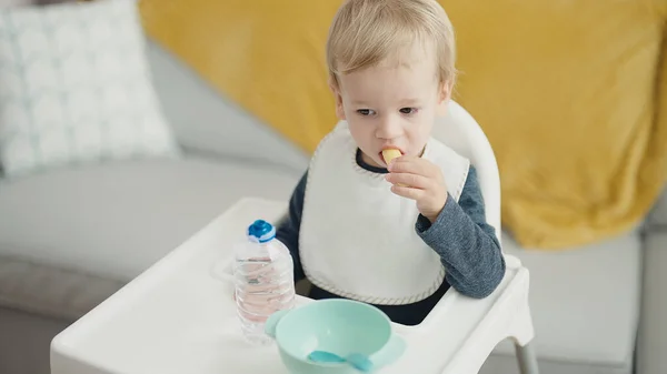 Adorável Loira Criança Sentada Cadeira Alta Comer Lanche Casa — Fotografia de Stock