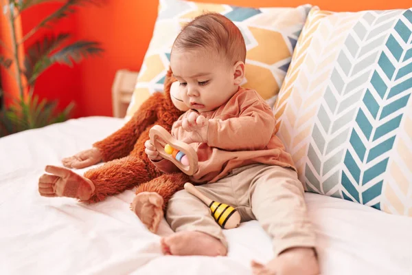 스러운 잠꾸러기 아기가 침대에 누워서 장난감을 가지고 — 스톡 사진