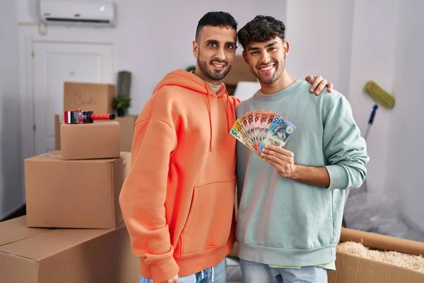 Young Hispanic Gay Couple Moving New Home Holding Banknotes Looking — ストック写真
