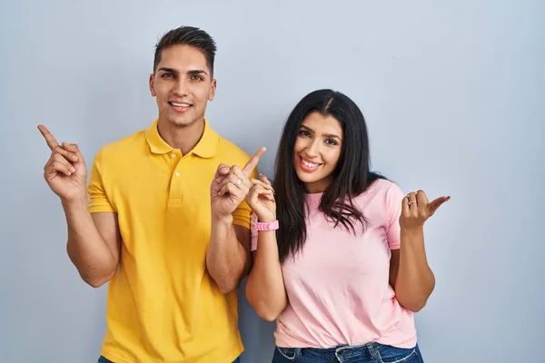 Young Couple Standing Isolated Background Smiling Confident Pointing Fingers Different — Fotografia de Stock