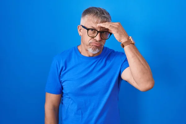 Hispanic Man Grey Hair Standing Blue Background Worried Stressed Problem — Stockfoto