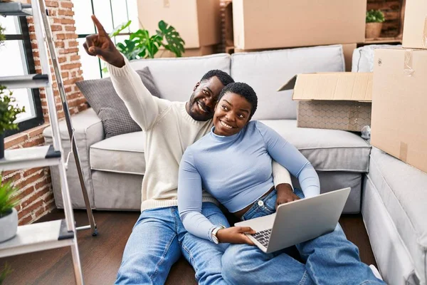 stock image Man and woman couple using laptop sitting on floor at new home