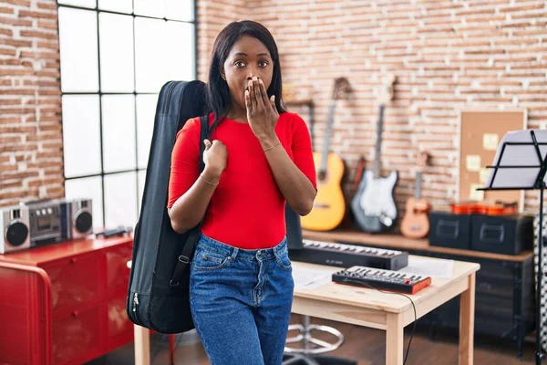 African Young Woman Wearing Guitar Case Music Studio Covering Mouth — Foto de Stock