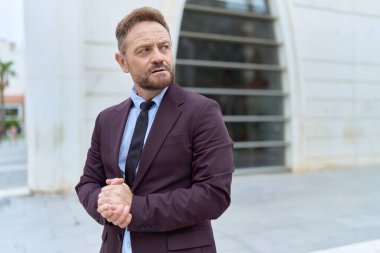 Middle age man business worker standing with serious expression at street