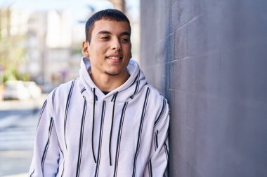 Sokakta kendine güvenen genç adam gülümsüyor