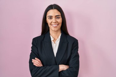 Young brunette woman wearing business style over pink background happy face smiling with crossed arms looking at the camera. positive person. 