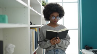 Afrikalı Amerikalı kadın yeni evinde karton kutu paketliyor.