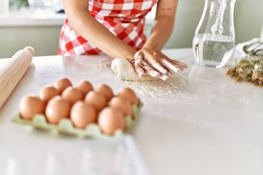 Genç ve güzel İspanyol kadın mutfakta elleriyle ekmek hamuru yoğuruyor.