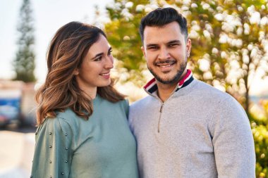 Man and woman smiling confident hugging each other standing at park