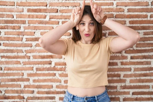 Young Brunette Woman Standing Bricks Wall Doing Funny Gesture Finger — Stock Photo, Image