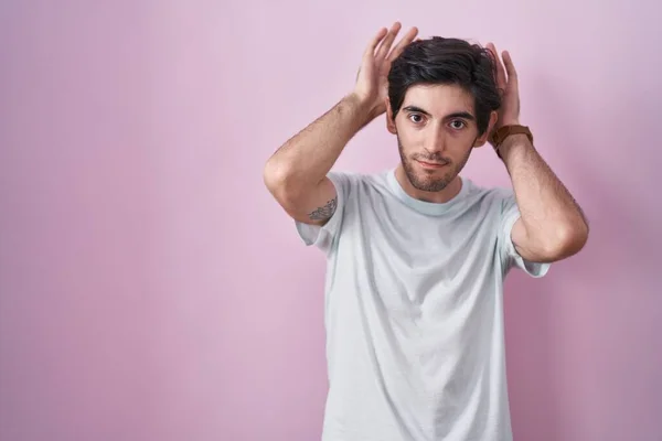 Young Hispanic Man Standing Pink Background Doing Bunny Ears Gesture — Stock Photo, Image