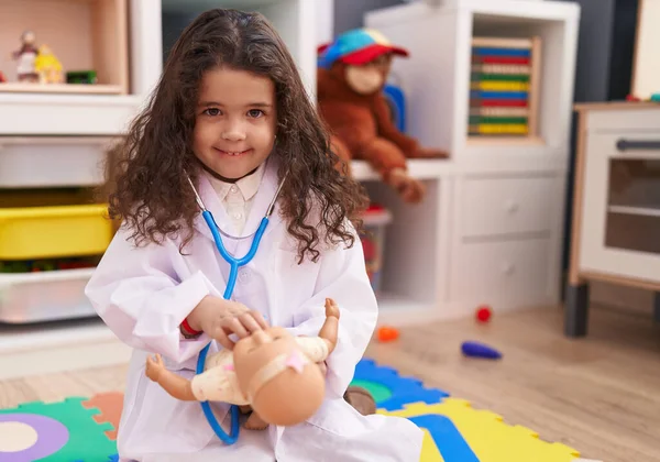 Adorable Hispanic Girl Wearing Doctor Uniform Auscultating Baby Doll Kindergarten — Stockfoto