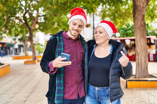 Μητέρα Και Γιος Φορούν Χριστουγεννιάτικο Καπέλο Χρησιμοποιώντας Smartphone Στο Πάρκο — Φωτογραφία Αρχείου