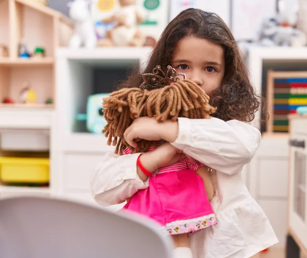 Urocza Latynoska Dziewczyna Przytulająca Lalkę Stojąca Przedszkolu — Zdjęcie stockowe