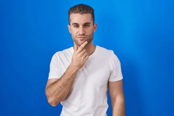 Young Caucasian Man Standing Blue Background Thinking Concentrated Doubt Finger — Foto de Stock