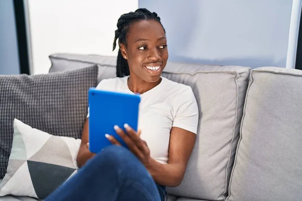 African American Woman Using Touchpad Sitting Sofa Home — стоковое фото