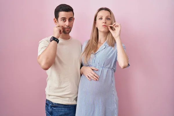 Casal Jovem Esperando Bebê Sobre Boca Fundo Rosa Lábios Fechados — Fotografia de Stock