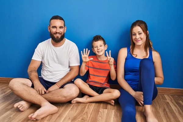 Family Three Sitting Floor Home Showing Pointing Fingers Number Seven — Stock Photo, Image