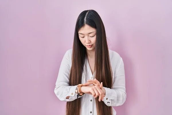 Chinese Young Woman Standing Pink Background Checking Time Wrist Watch — Stockfoto