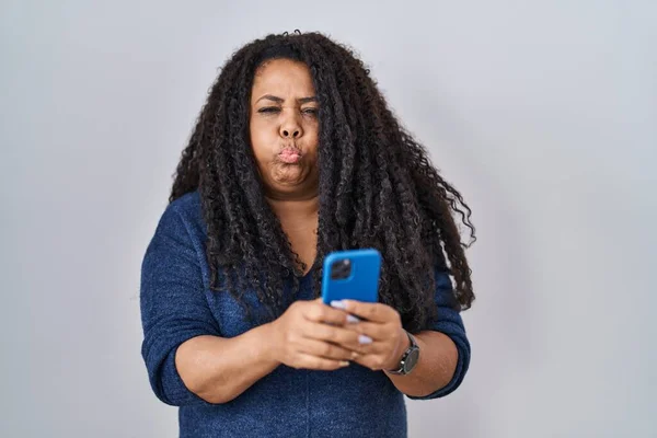 Size Hispanic Woman Using Smartphone Typing Message Puffing Cheeks Funny — Stockfoto