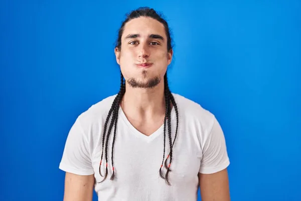 Hispanic Man Long Hair Standing Blue Background Puffing Cheeks Funny — Stockfoto