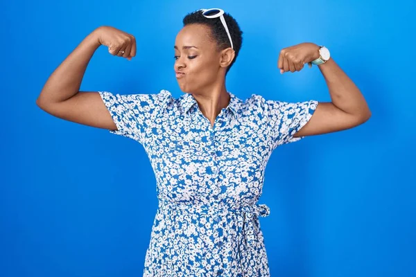 Африканская Американка Стоящая Синем Фоне Показывает Мускулы Рук Гордо Улыбающиеся — стоковое фото