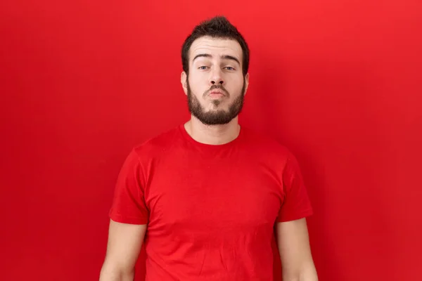 Latin Asıllı Genç Adam Sıradan Kırmızı Tişörtler Giyip Kameraya Bakıyor — Stok fotoğraf